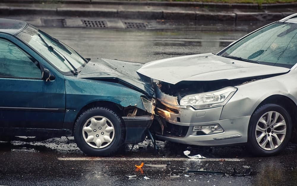 Car accident on wet road during rain, head on collision side view.